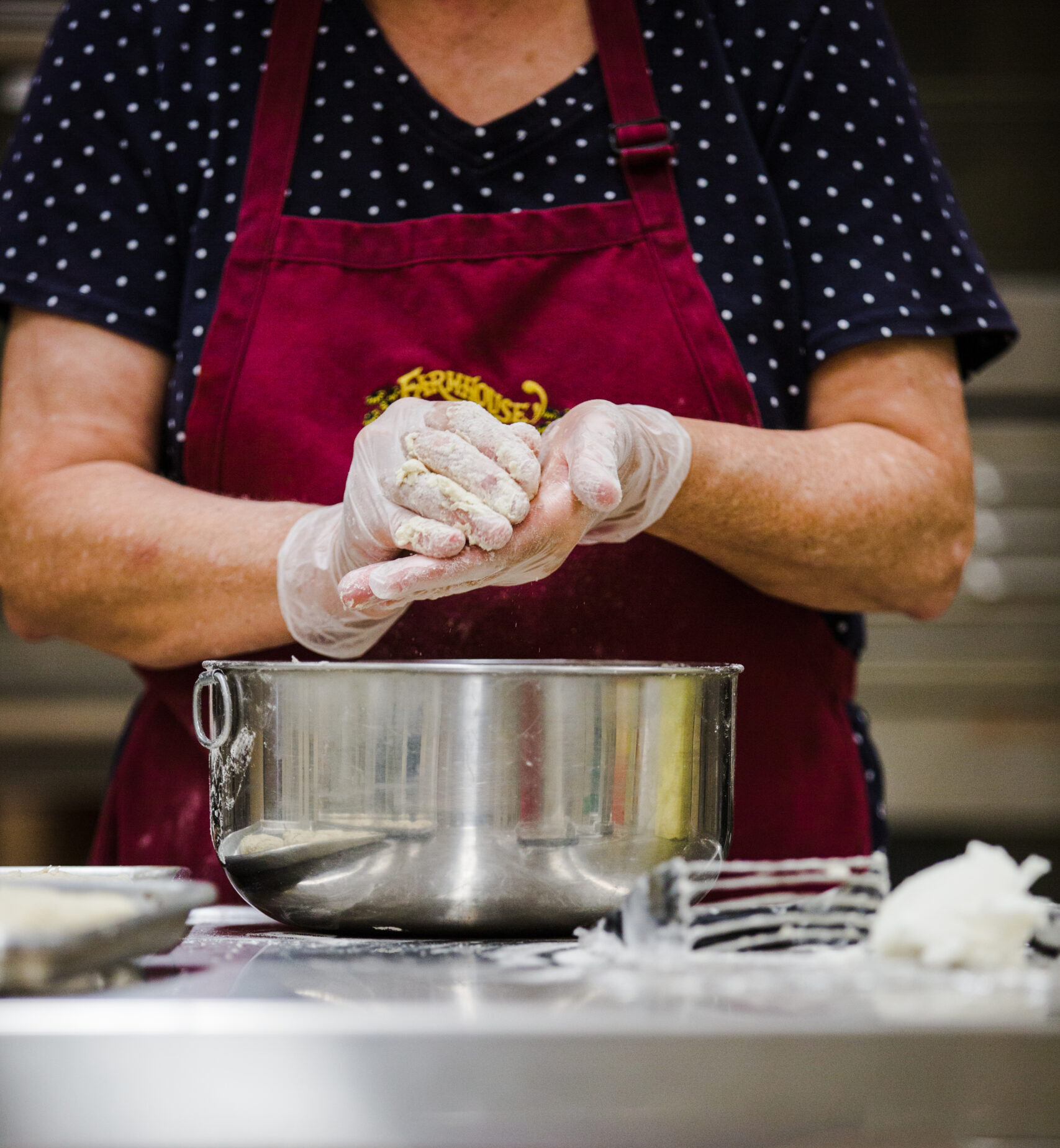 Woman in magenta apron prepares food