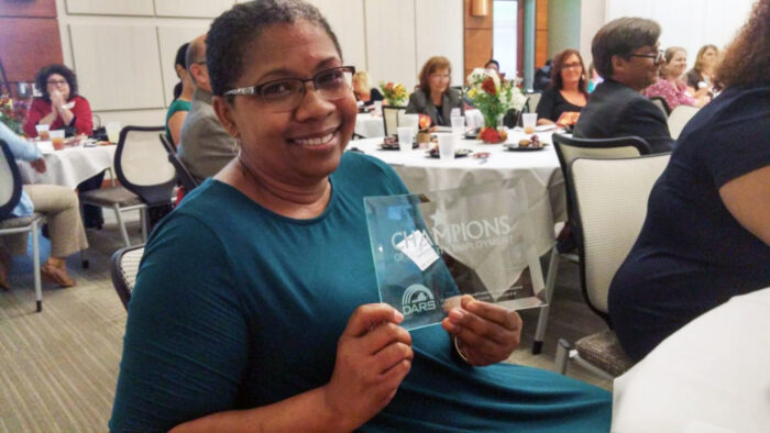 Community Recovery Program’s Program Manager Lisa Smith with the Champions award for community collaboration.
